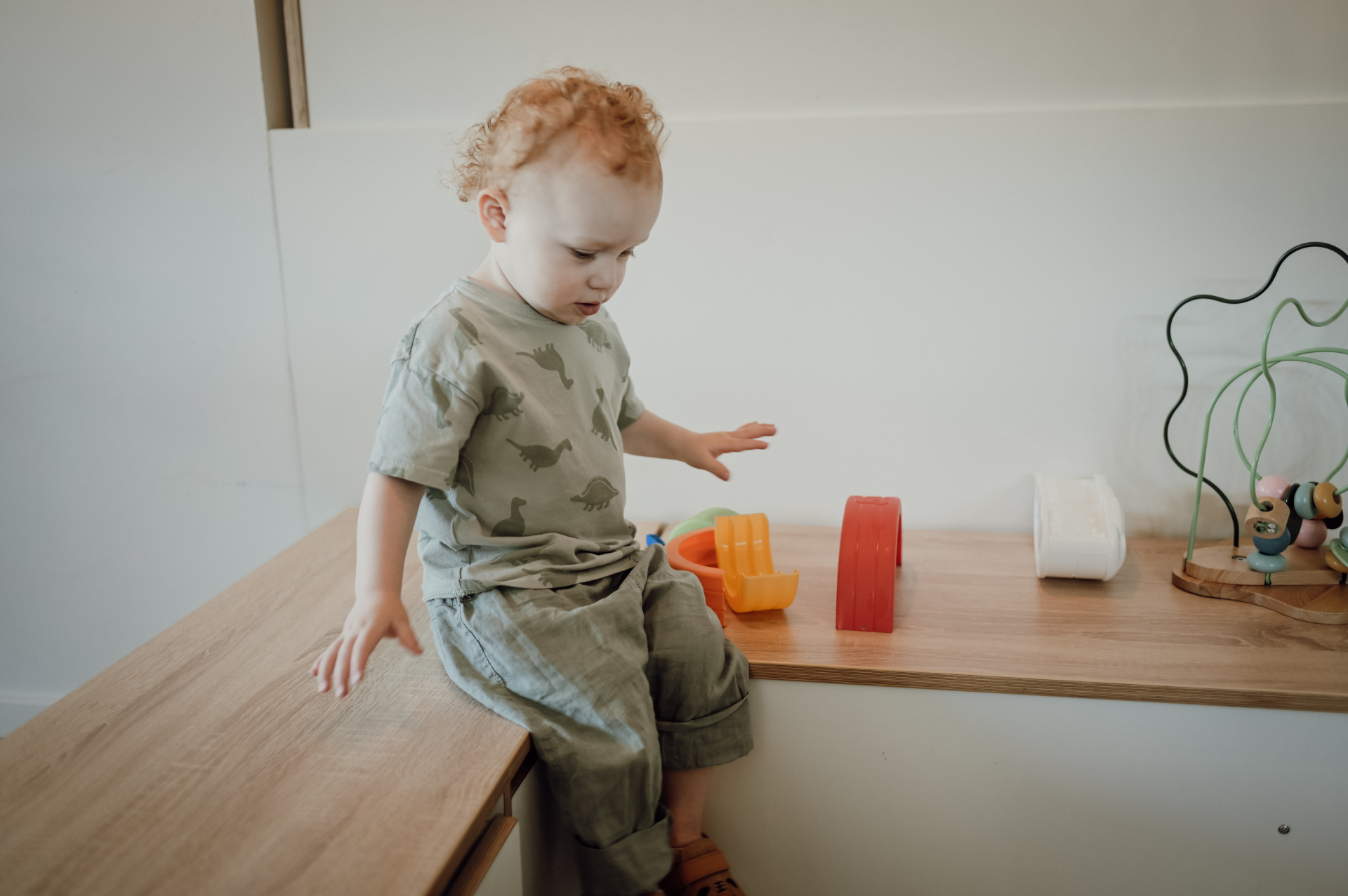 kind zit op houten bankje kijkt naar beneden