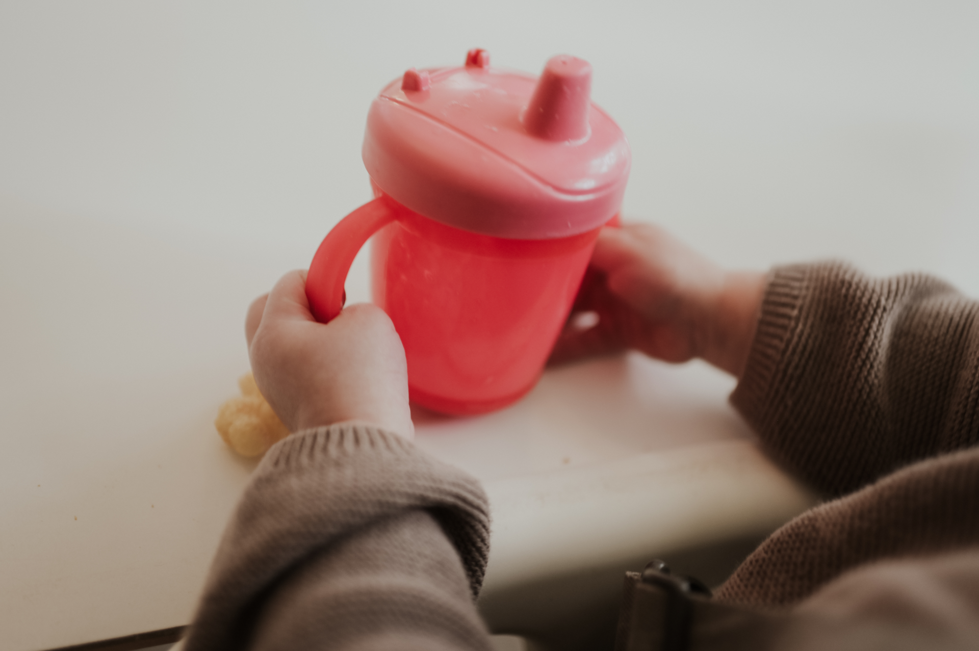 rode beker wordt vastgehouden door twee kinderhanden