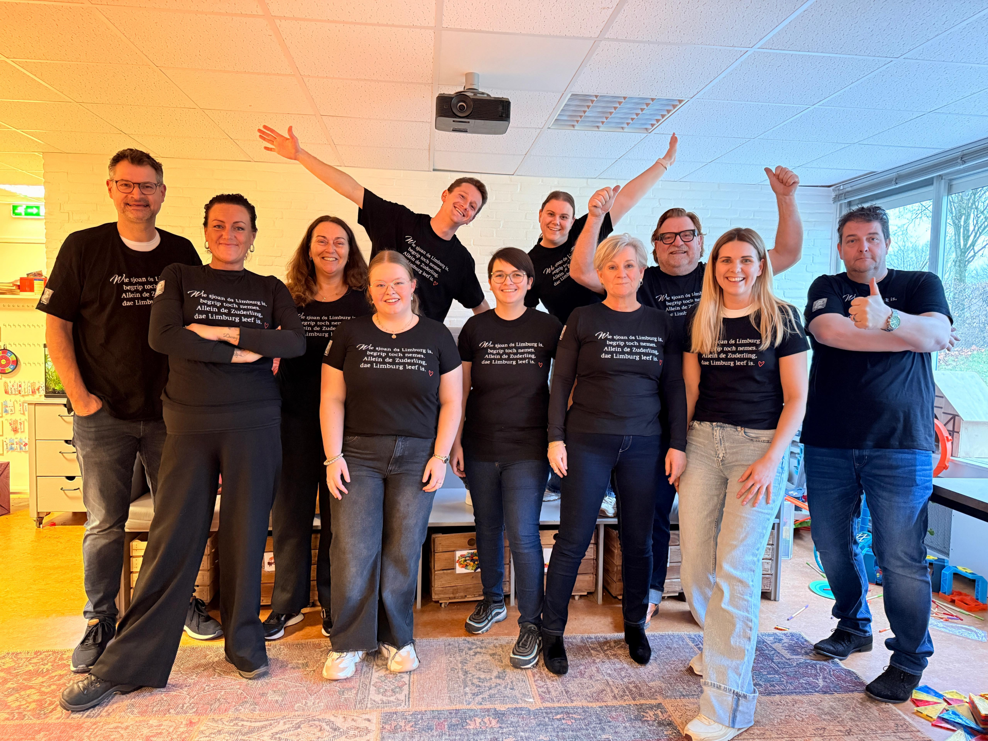 groep volwassenen in zwarte t-shirts van ton meisen poseert lachend voor camera